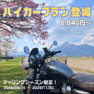 春の磐梯山を背景に、満開の桜の下に停められた黒いツーリングバイク